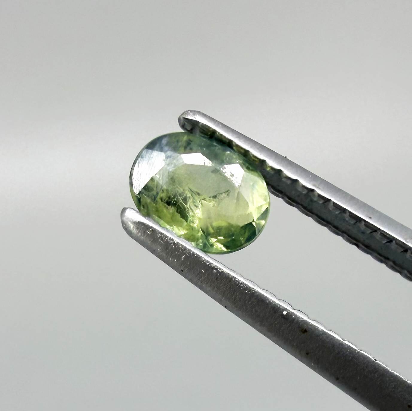Oval green sapphire from Thailand, 0.35ct, unheated, with fresh green hues, visible natural inclusions and a transparent to slightly silky appearance.