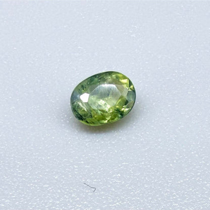 Oval green sapphire from Thailand, 0.35ct, unheated, with fresh green hues, visible natural inclusions and a transparent to slightly silky appearance.