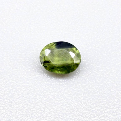 Oval green sapphire from Thailand, 0.37ct, unheated, with olive to deep green color zoning, visible natural inclusions and a transparent to slightly silky appearance.