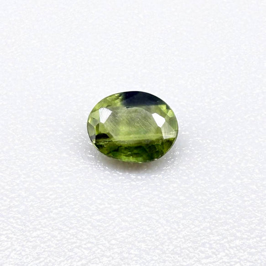 Oval green sapphire from Thailand, 0.37ct, unheated, with olive to deep green color zoning, visible natural inclusions and a transparent to slightly silky appearance.