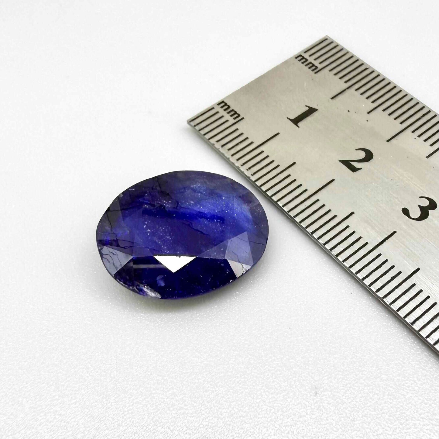Large enhanced deep blue sapphire 17.2 ct with intense vivid blue color and faceted oval cut statement appearance