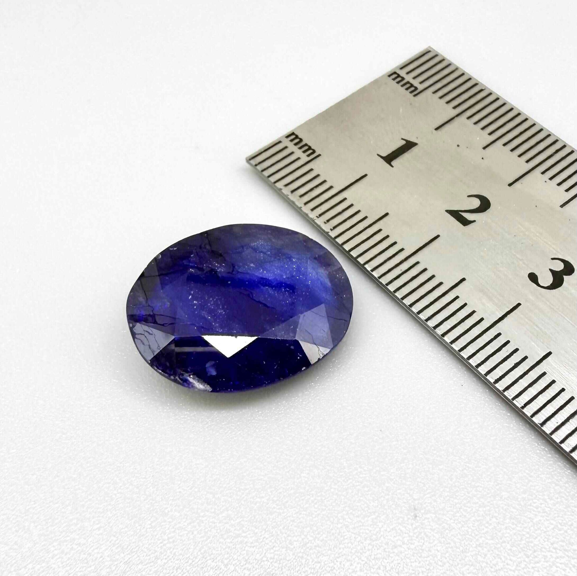 Large enhanced deep blue sapphire 17.2 ct with intense vivid blue color and faceted oval cut statement appearance