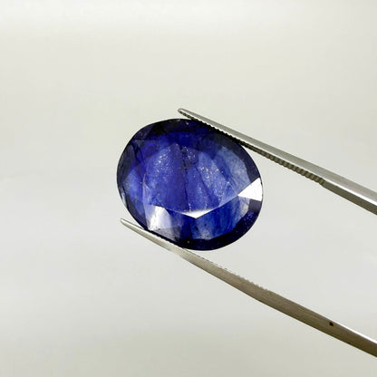 Large enhanced deep blue sapphire 17.2 ct with intense vivid blue color and faceted oval cut statement appearance