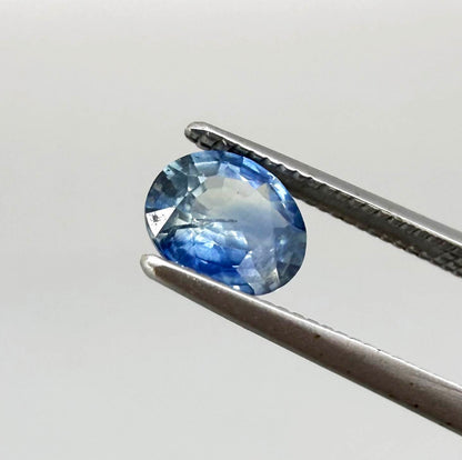 Oval cut light medium blue sapphire from Bangkaja, Thailand with natural color zoning and faceted brilliance.