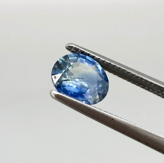 Oval cut light medium blue sapphire from Bangkaja, Thailand with natural color zoning and faceted brilliance.