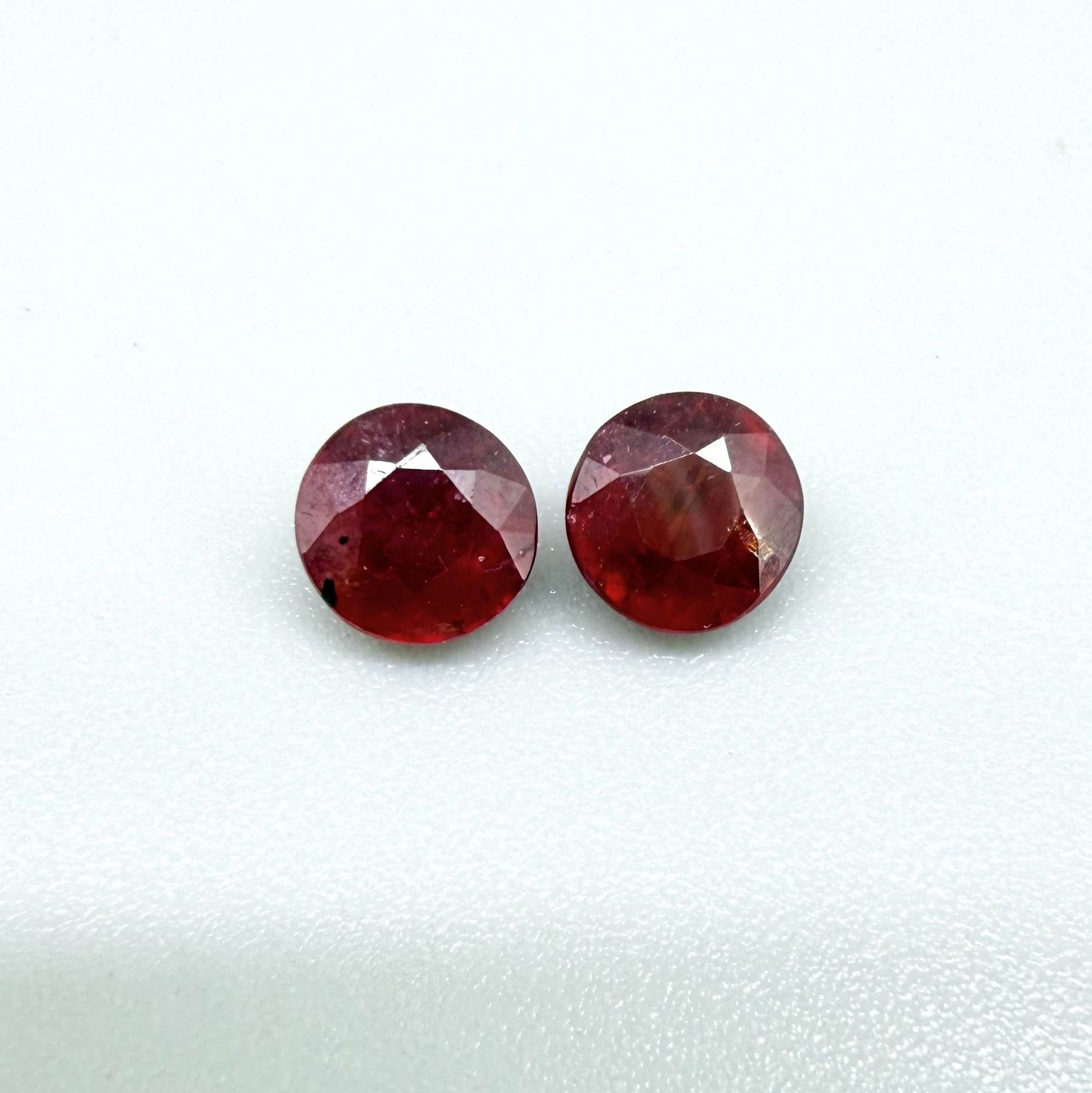 Natural Mozambique ruby pair in round cut, 2.20 ct total weight, enhanced and precisely matched.