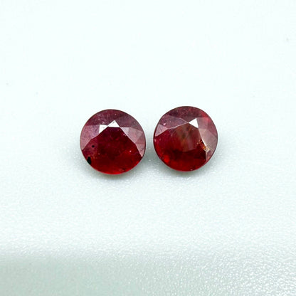Natural Mozambique ruby pair in round cut, 2.20 ct total weight, enhanced and precisely matched.