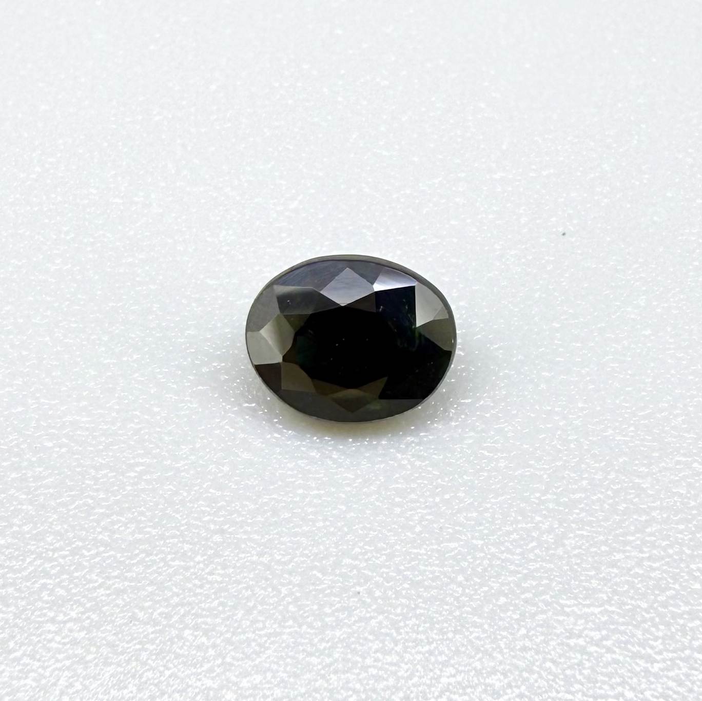 Oval dark blue heated sapphire from Laos weighing 0.87 ct, featuring a deep blue color and eye-clean clarity.