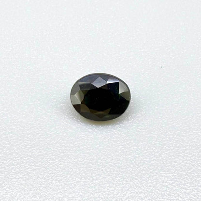 Oval dark blue heated sapphire from Laos weighing 0.87 ct, featuring a deep blue color and eye-clean clarity.