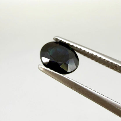 Oval dark blue heated sapphire from Laos weighing 0.87 ct, featuring a deep blue color and eye-clean clarity.