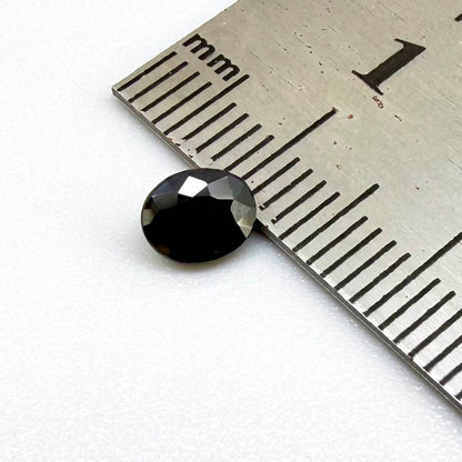 Oval dark blue heated sapphire from Laos weighing 0.87 ct, featuring a deep blue color and eye-clean clarity.
