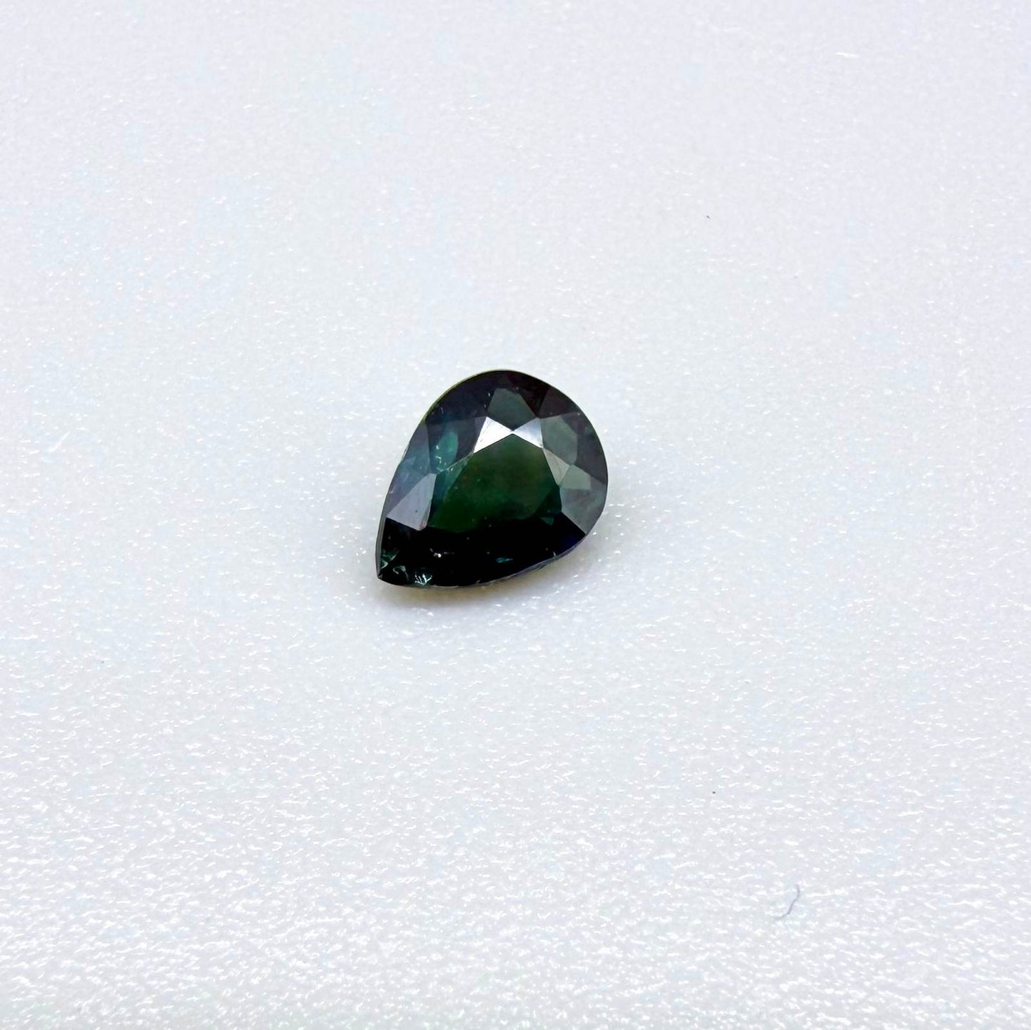 Deep teal blue-green Laos sapphire pear weighing 0.45 ct, heated and eye-clean.