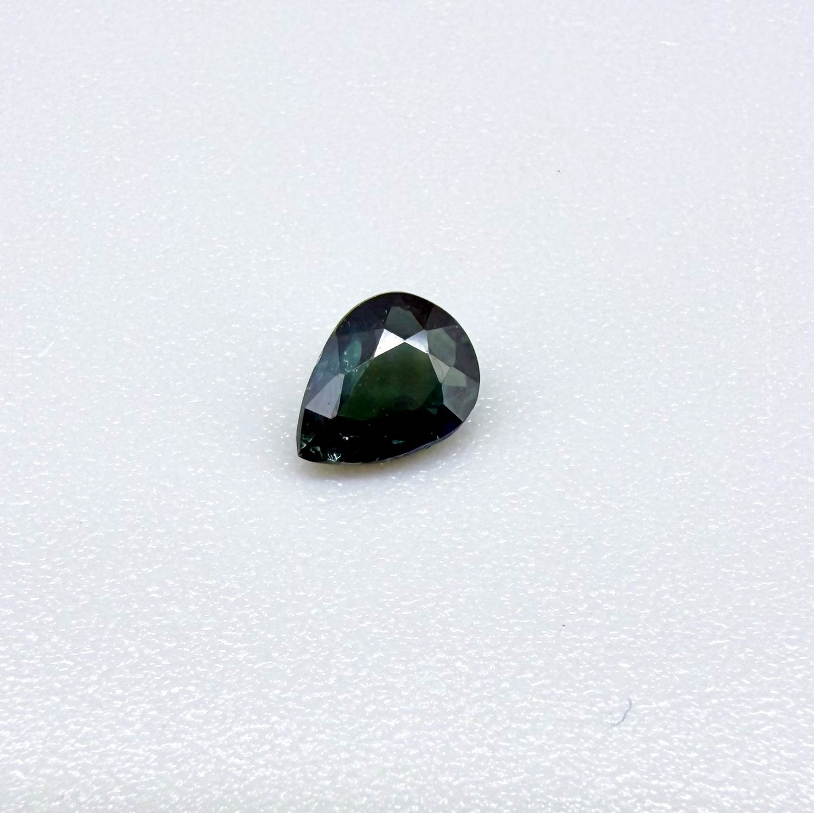 Deep teal blue-green Laos sapphire pear weighing 0.45 ct, heated and eye-clean.