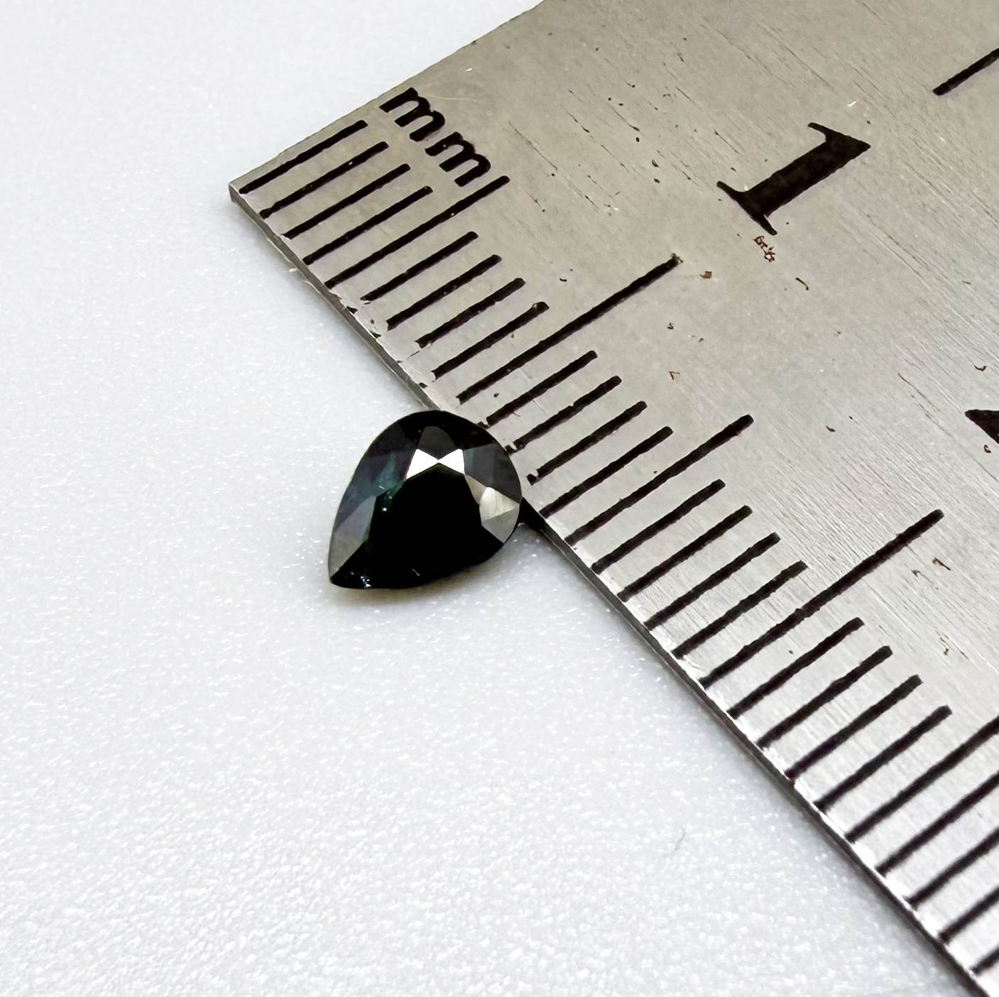 Deep teal blue-green Laos sapphire pear weighing 0.45 ct, heated and eye-clean.