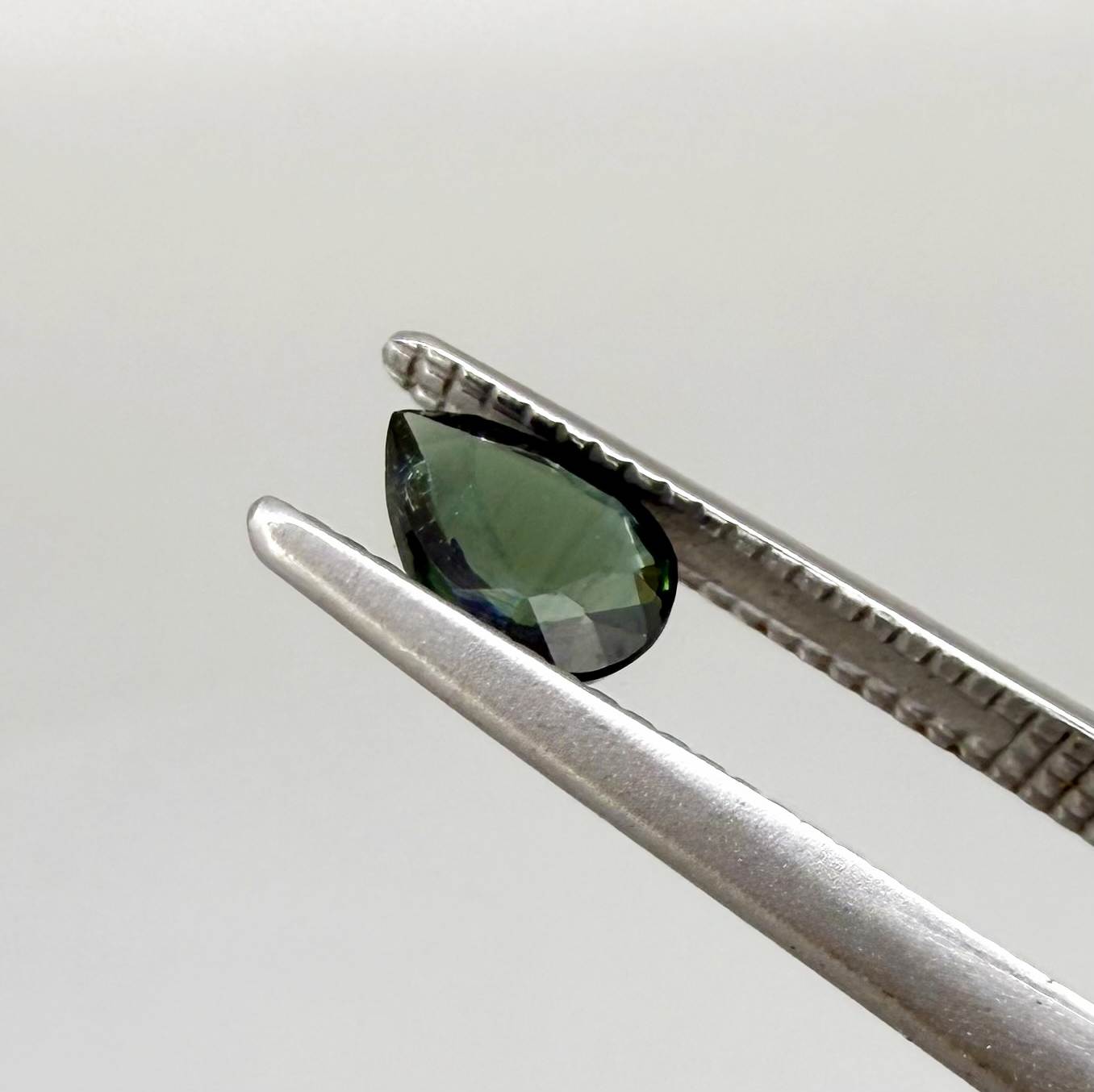Deep teal blue-green Laos sapphire pear weighing 0.45 ct, heated and eye-clean.