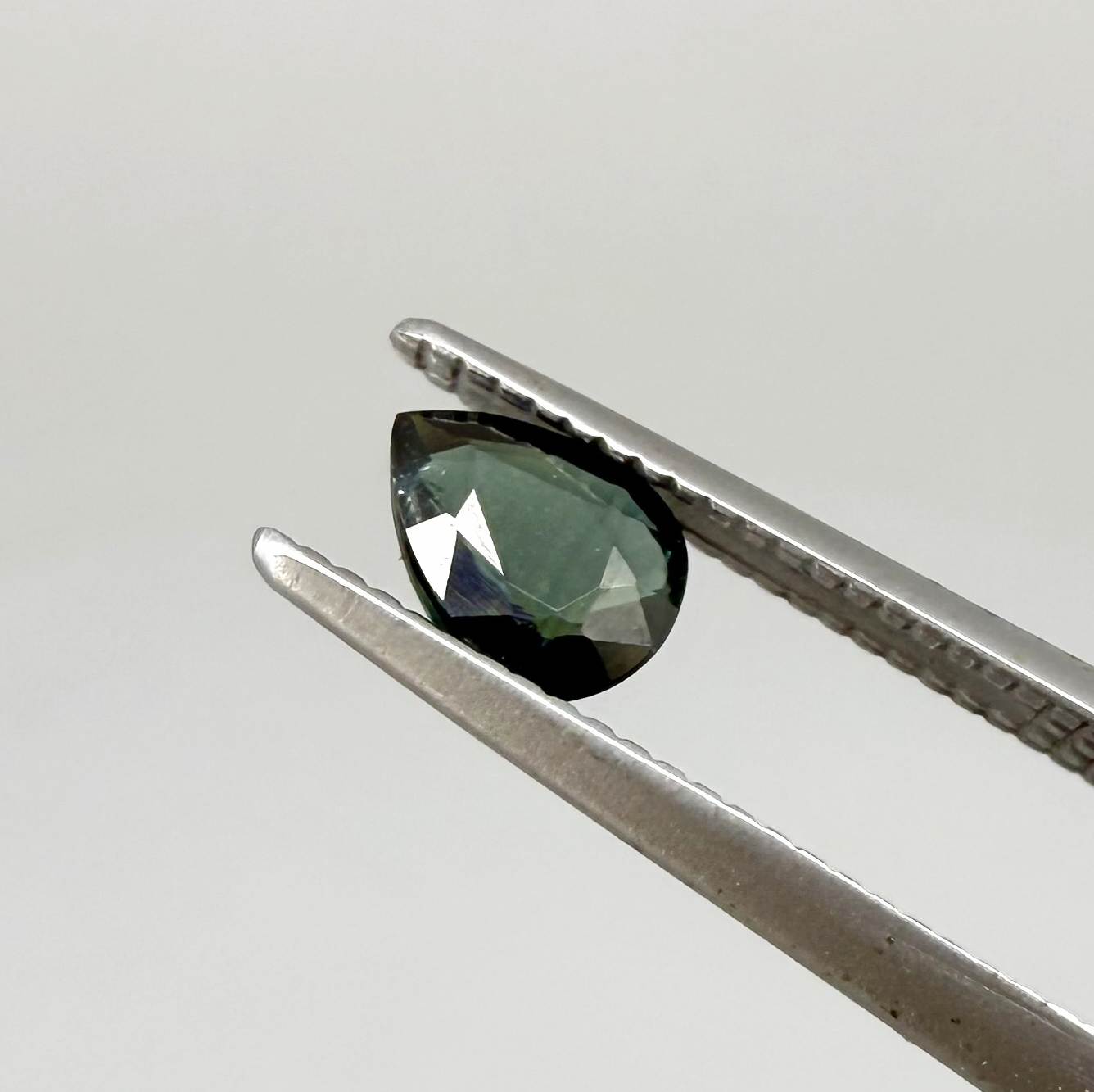 Deep teal blue-green Laos sapphire pear weighing 0.45 ct, heated and eye-clean.