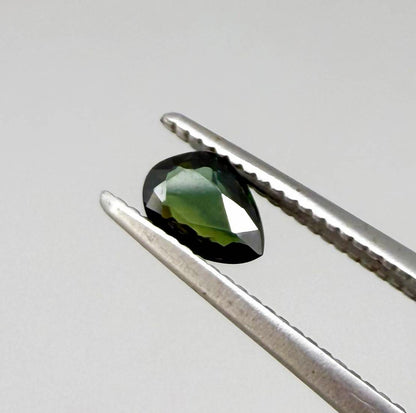 Olive green pear-shaped Laos sapphire weighing 0.39 ct, heated and eye-clean.