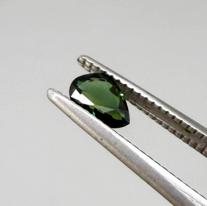 Olive green pear-shaped Laos sapphire weighing 0.39 ct, heated and eye-clean.