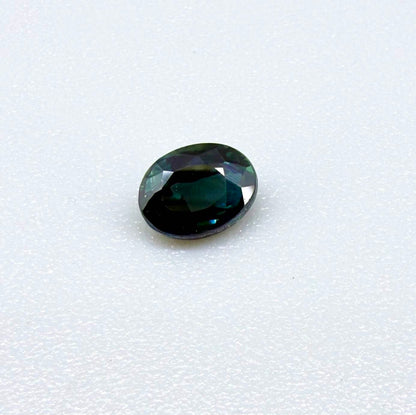 0.57 ct teal blue Laos sapphire in oval cut, heated and eye-clean with vivid blue-green tones.