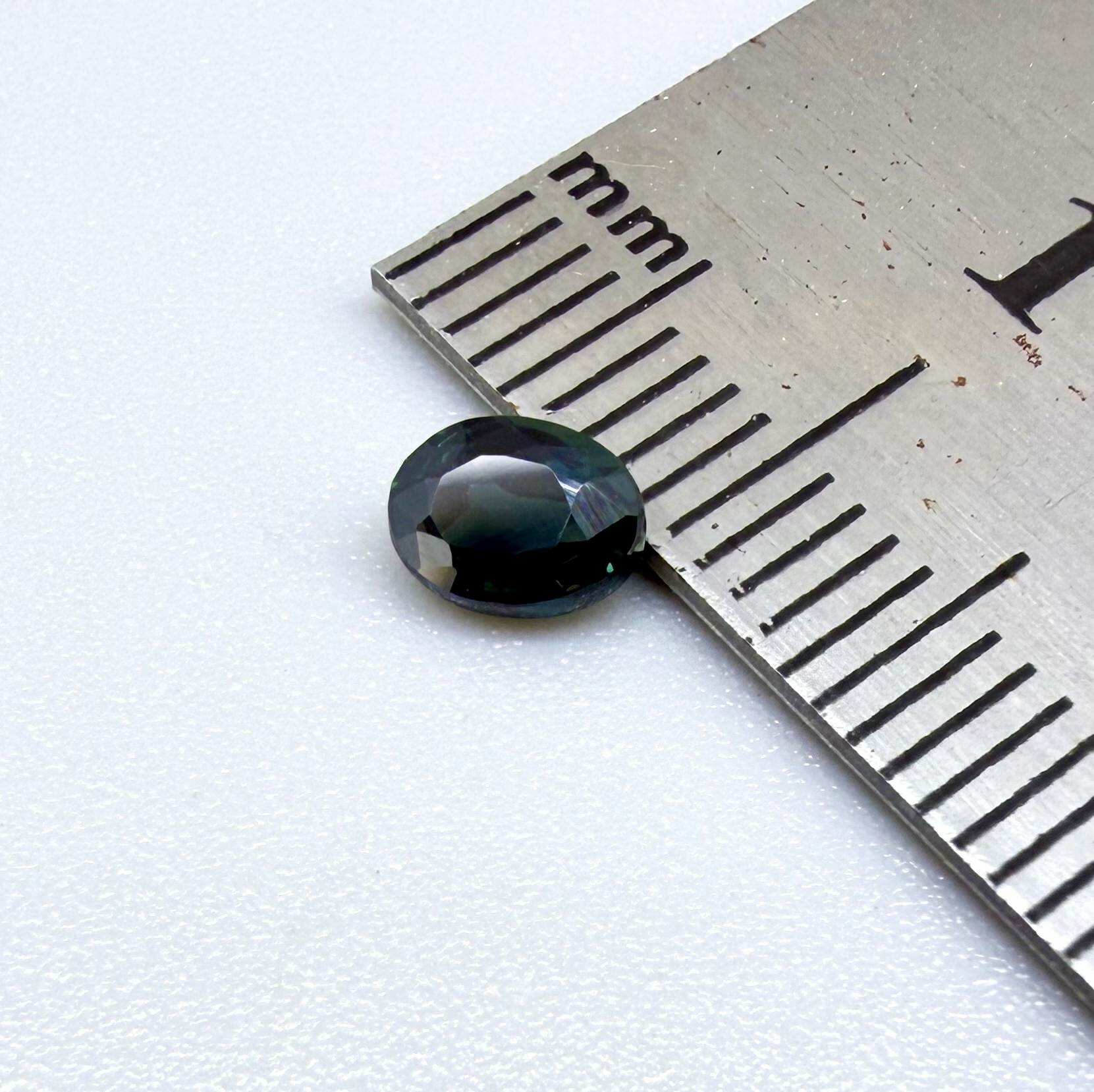 0.57 ct teal blue Laos sapphire in oval cut, heated and eye-clean with vivid blue-green tones.