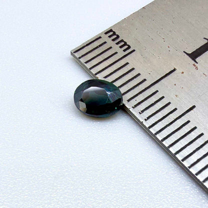 0.57 ct teal blue Laos sapphire in oval cut, heated and eye-clean with vivid blue-green tones.