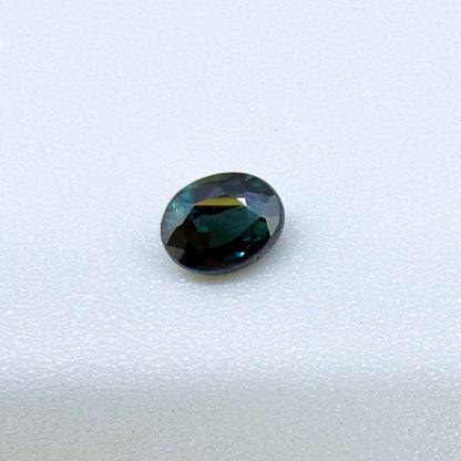 0.57 ct teal blue Laos sapphire in oval cut, heated and eye-clean with vivid blue-green tones.