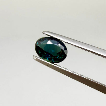 0.57 ct teal blue Laos sapphire in oval cut, heated and eye-clean with vivid blue-green tones.