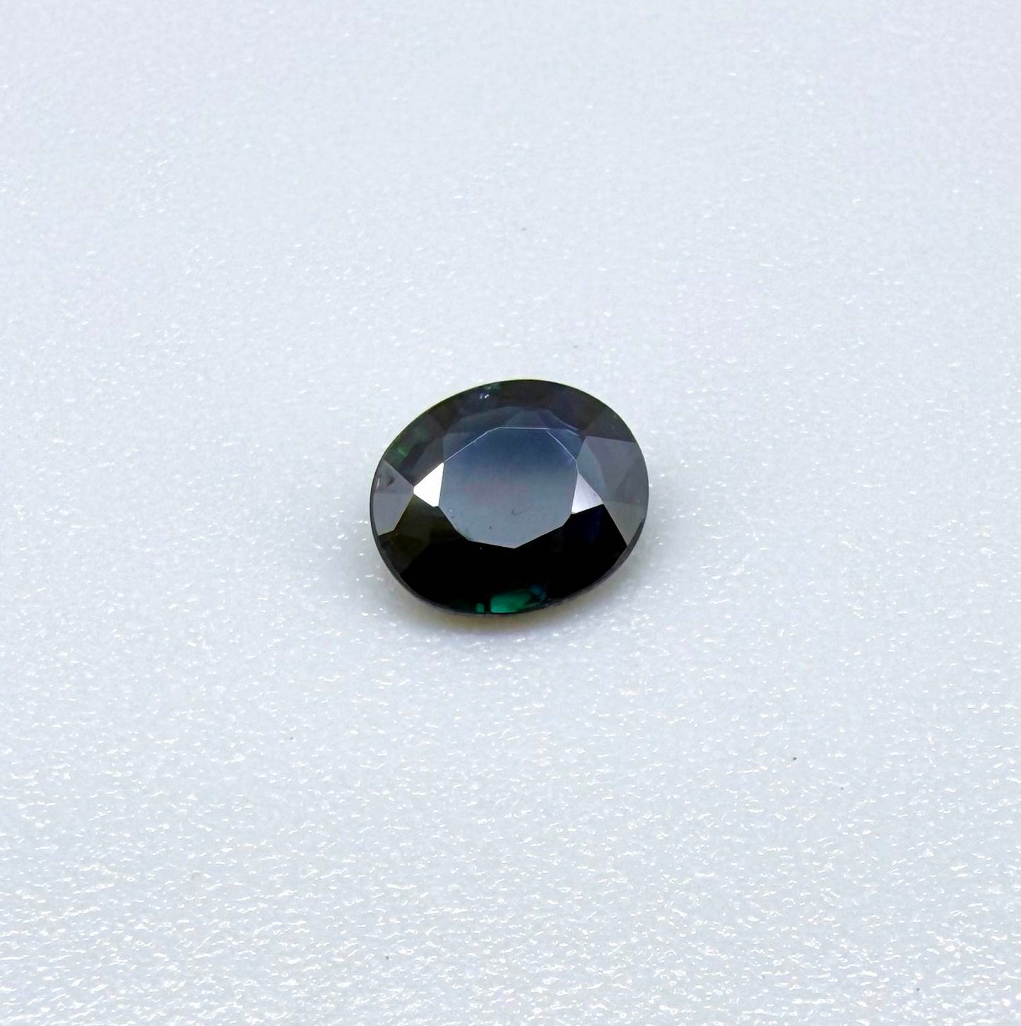 0.55 ct deep teal blue Laos sapphire in oval cut, heated and eye-clean with captivating blue-green tones.