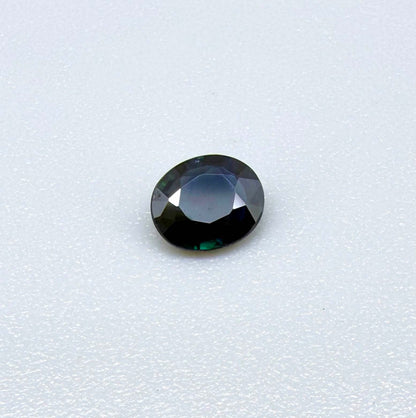 0.55 ct deep teal blue Laos sapphire in oval cut, heated and eye-clean with captivating blue-green tones.