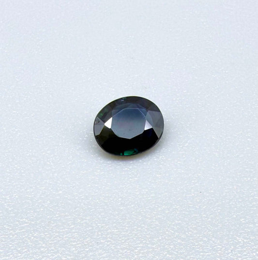 0.55 ct deep teal blue Laos sapphire in oval cut, heated and eye-clean with captivating blue-green tones.