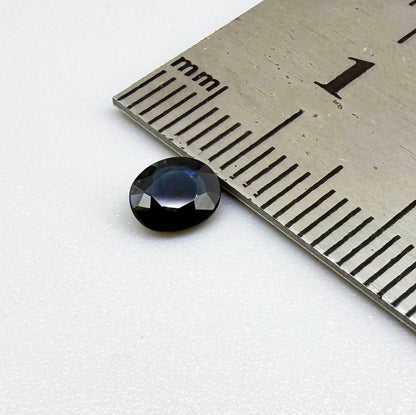 0.55 ct deep teal blue Laos sapphire in oval cut, heated and eye-clean with captivating blue-green tones.