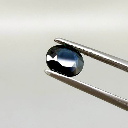 0.55 ct deep teal blue Laos sapphire in oval cut, heated and eye-clean with captivating blue-green tones.