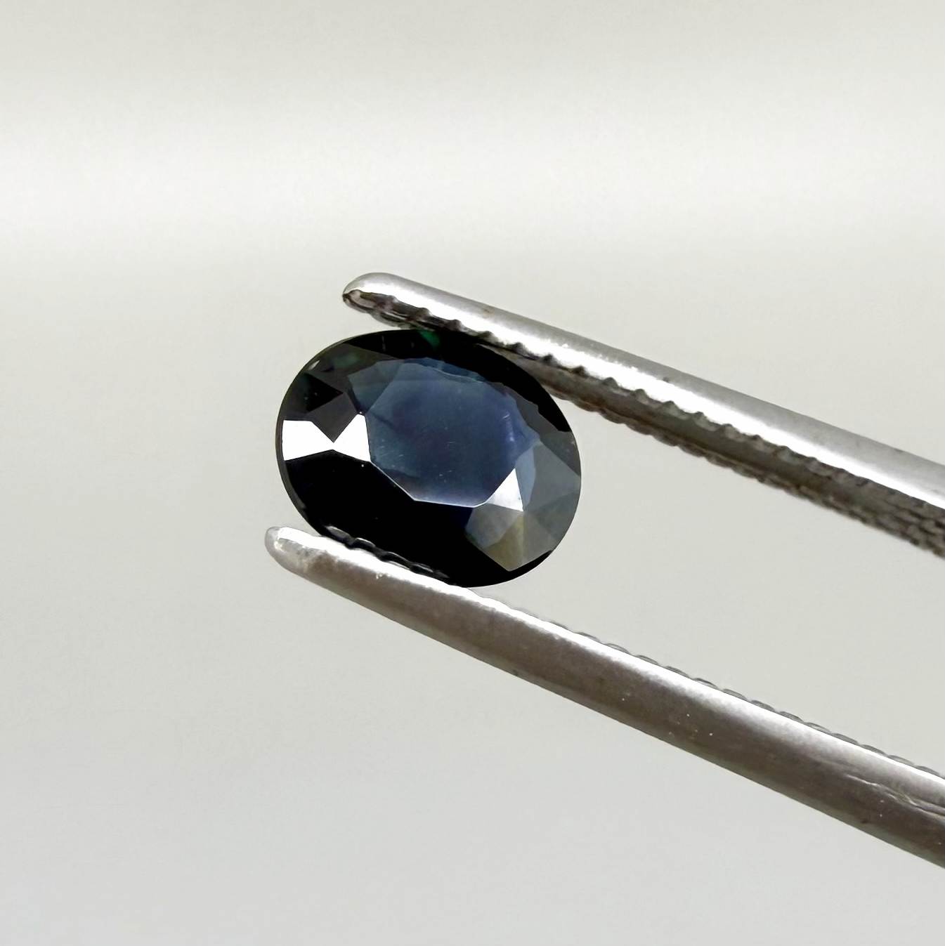 0.55 ct deep teal blue Laos sapphire in oval cut, heated and eye-clean with captivating blue-green tones.
