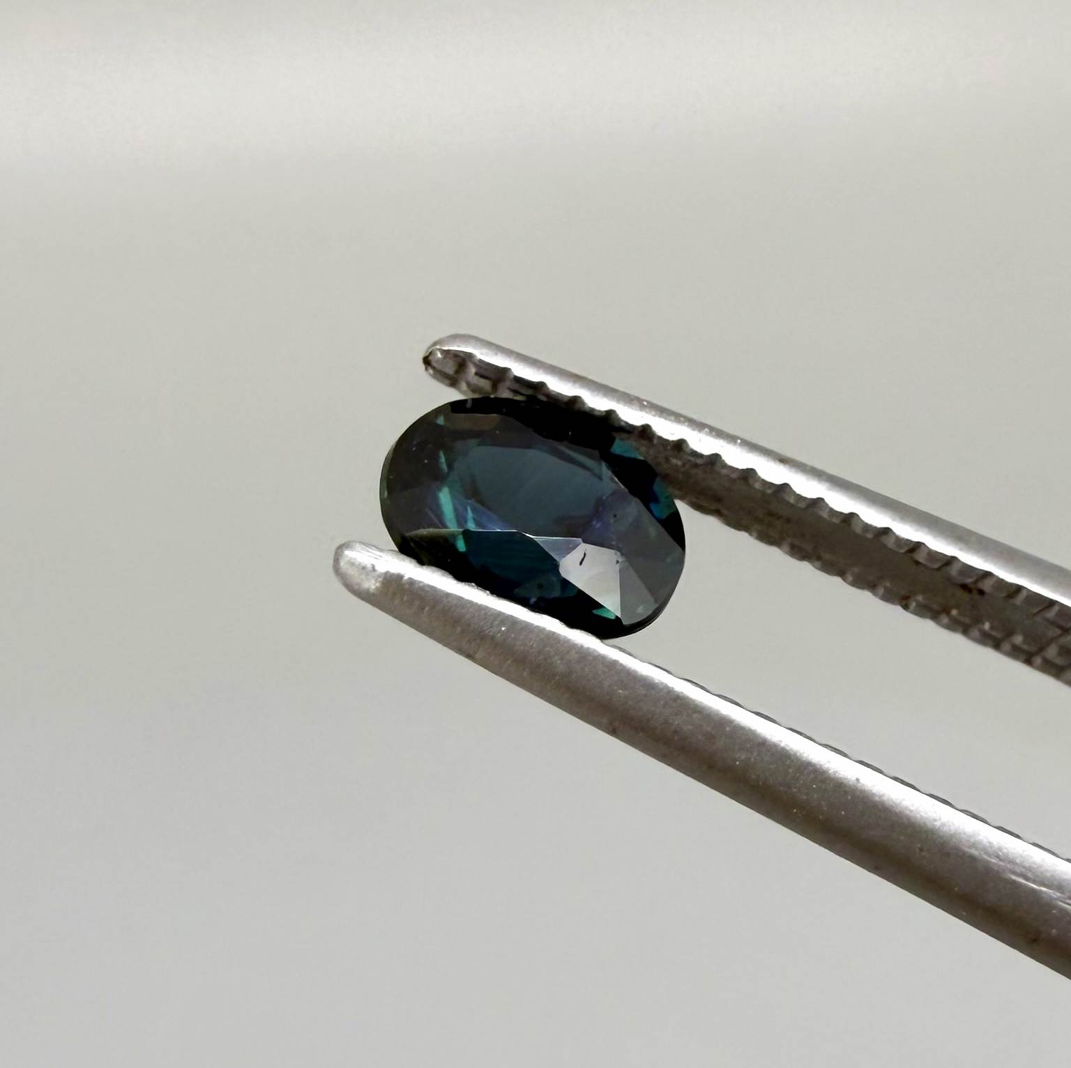 0.56 ct teal Laos sapphire in oval cut, heated and eye-clean with captivating blue-green color.