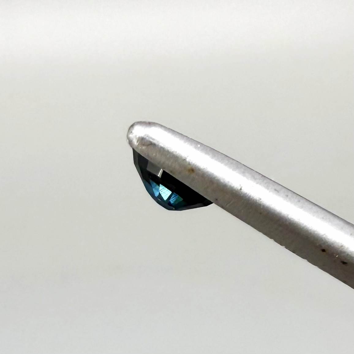 0.56 ct teal Laos sapphire in oval cut, heated and eye-clean with captivating blue-green color.