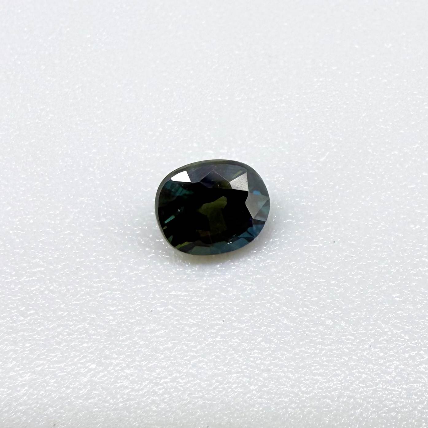 0.66 ct teal Laos sapphire in oval cut, heated and eye-clean with vivid blue-green color.