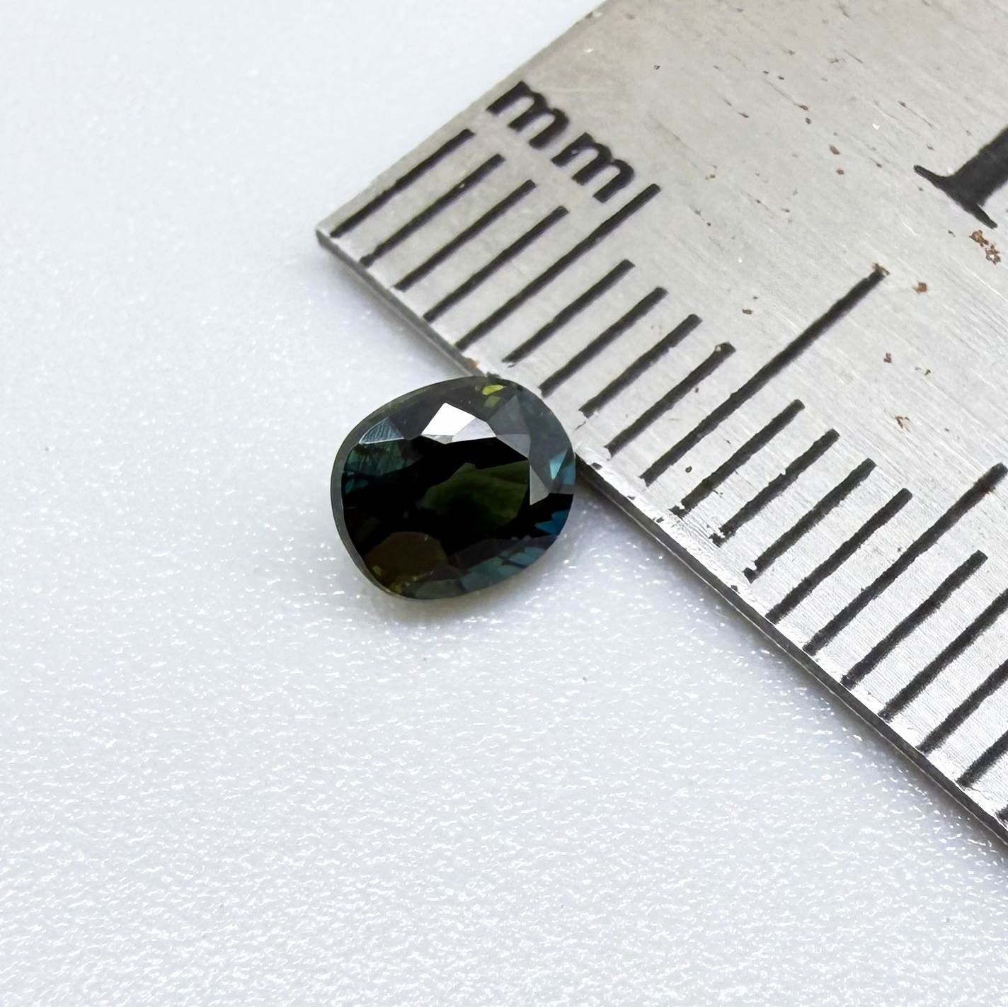 0.66 ct teal Laos sapphire in oval cut, heated and eye-clean with vivid blue-green color.