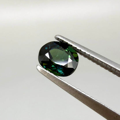 0.66 ct teal Laos sapphire in oval cut, heated and eye-clean with vivid blue-green color.