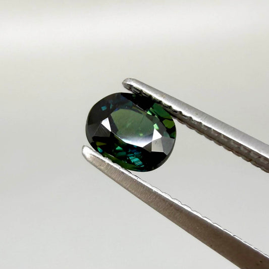 0.66 ct teal Laos sapphire in oval cut, heated and eye-clean with vivid blue-green color.