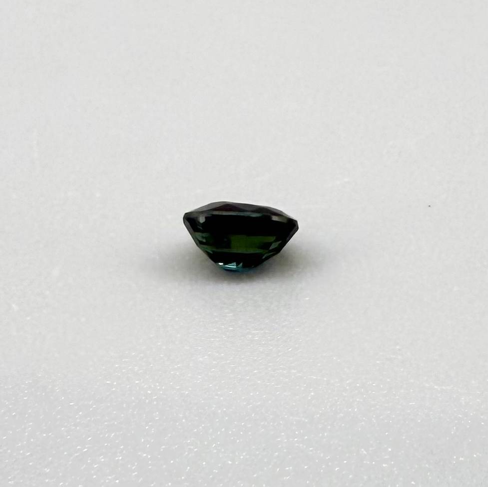 0.56 ct teal Laos sapphire in oval cut, heated and eye-clean with captivating blue-green color.