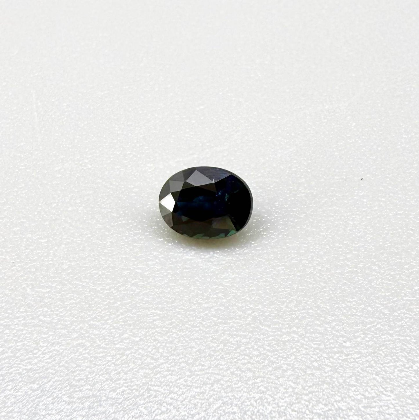 0.56 ct teal Laos sapphire in oval cut, heated and eye-clean with captivating blue-green color.