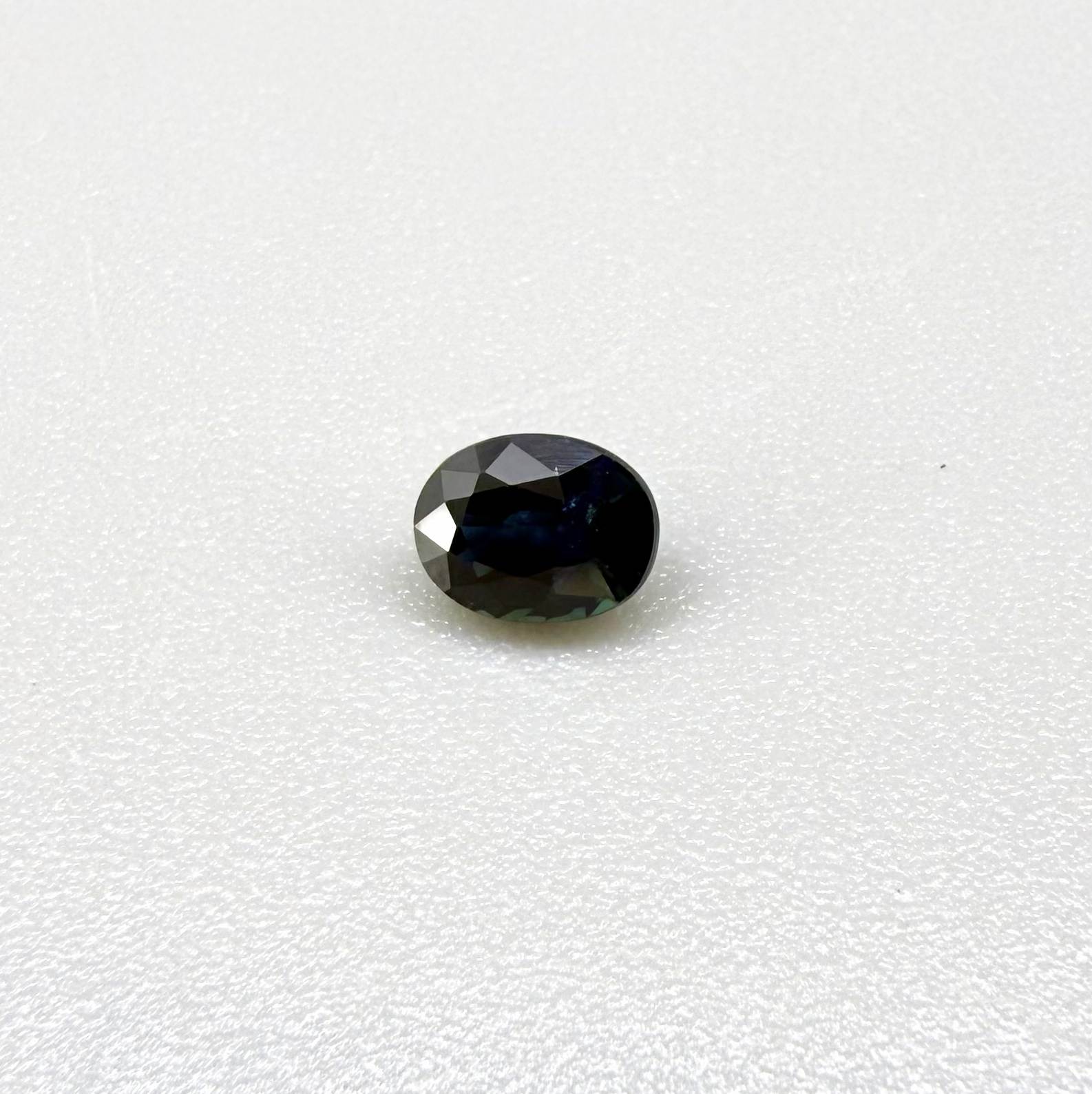 0.56 ct teal Laos sapphire in oval cut, heated and eye-clean with captivating blue-green color.