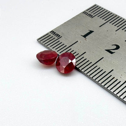 Natural Mozambique ruby pair in round cut, 2.20 ct total weight, enhanced and precisely matched.