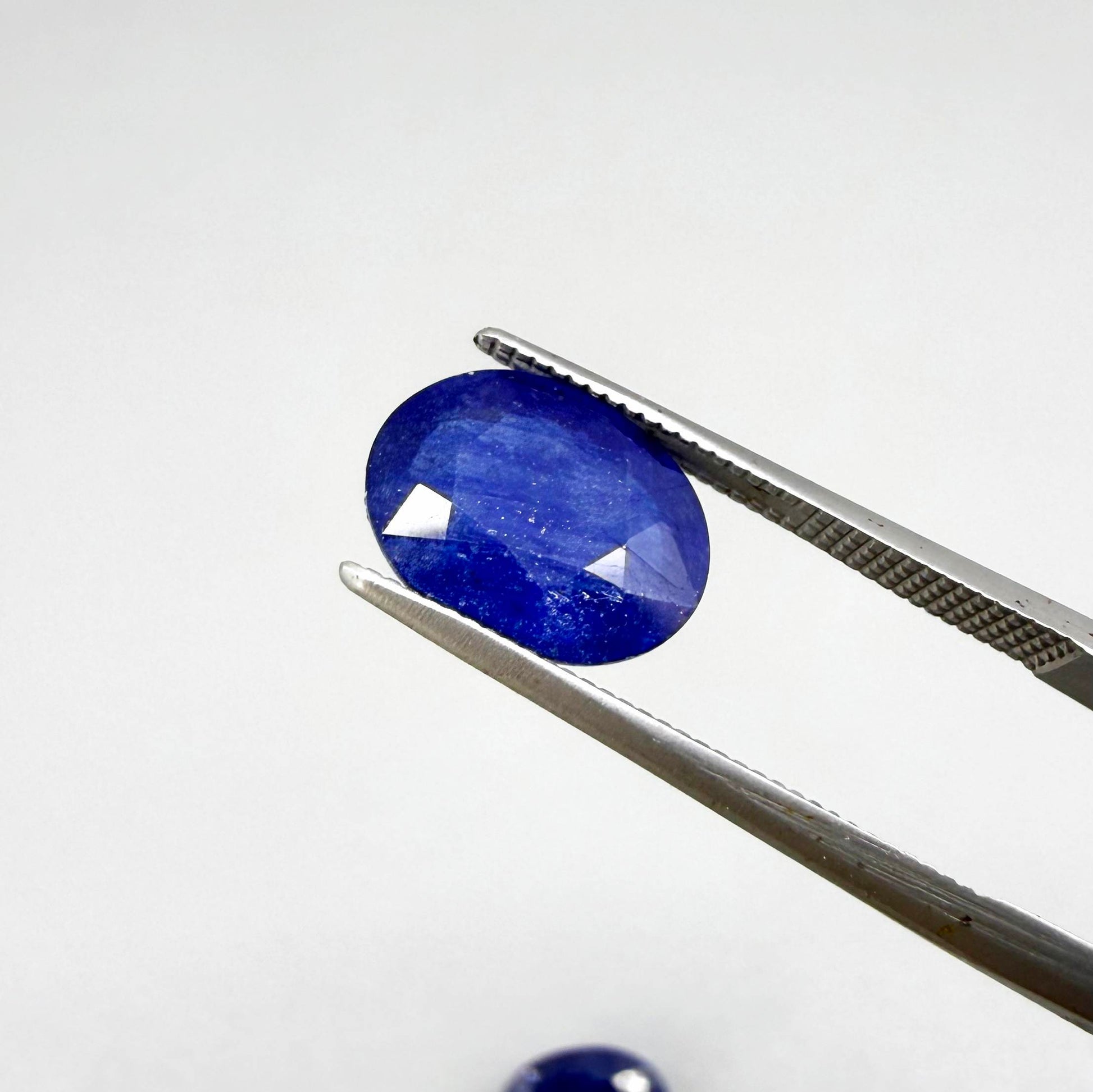 Large natural enhanced deep blue sapphire matching pair 7.71 ct oval faceted gemstones for earrings