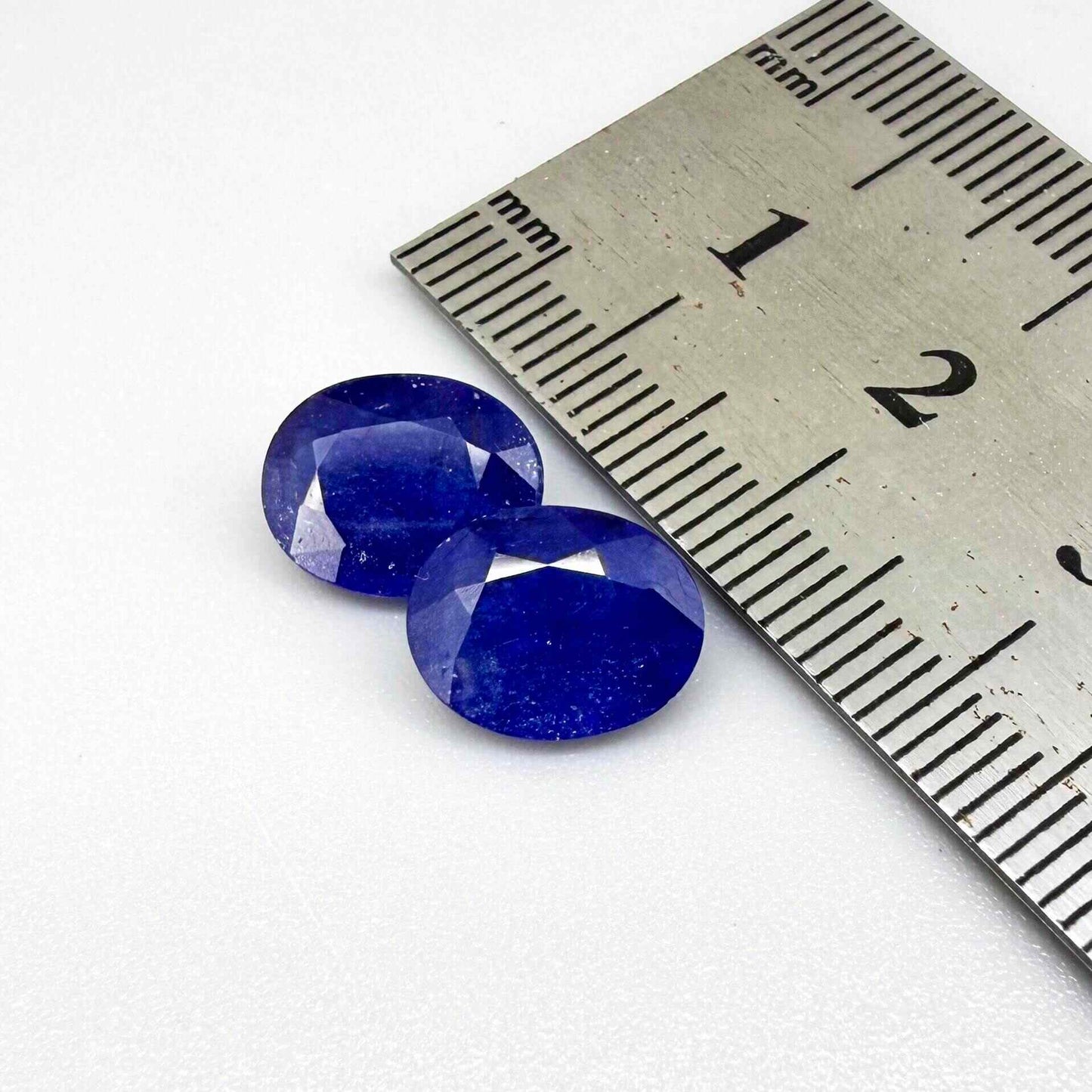 Large natural enhanced deep blue sapphire matching pair 7.71 ct oval faceted gemstones for earrings