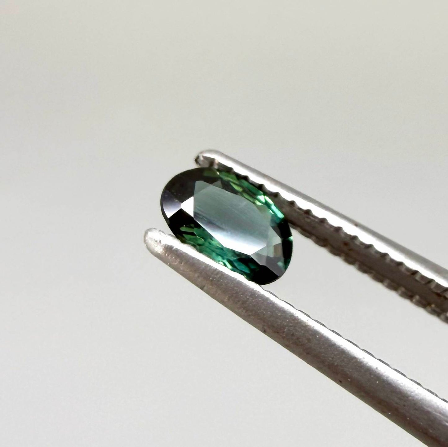 0.28 ct natural heated teal Laos sapphire with oval faceted cut and exceptional clarity