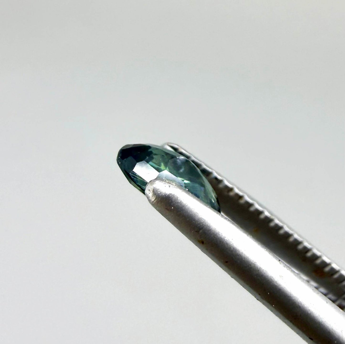 0.28 ct natural heated teal Laos sapphire with oval faceted cut and exceptional clarity