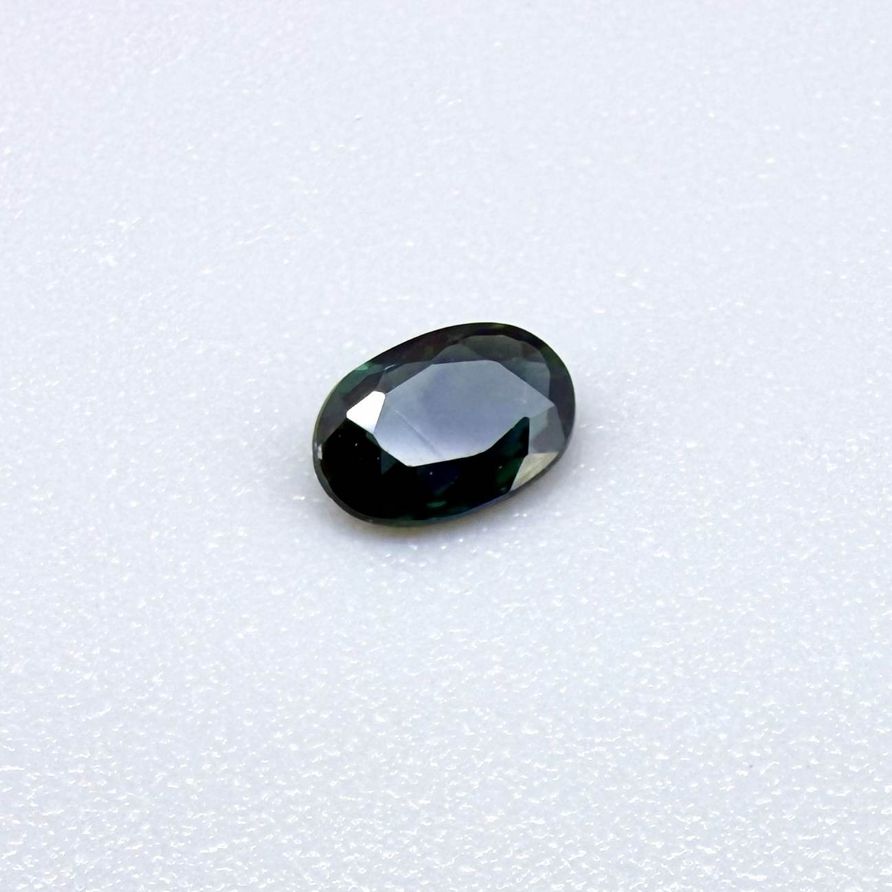 0.28 ct natural heated teal Laos sapphire with oval faceted cut and eye-clean clarity
