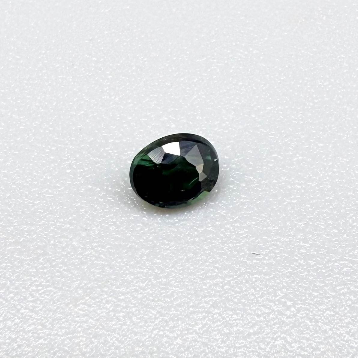0.36 ct natural heated teal Laos sapphire with oval faceted cut and excellent clarity