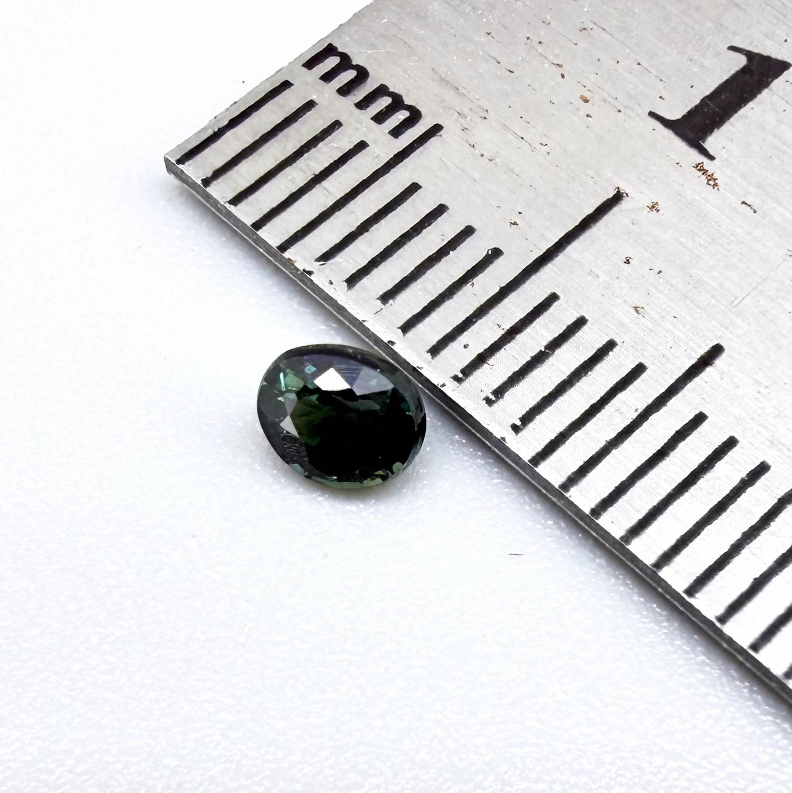 0.36 ct natural heated teal Laos sapphire with oval faceted cut and excellent clarity